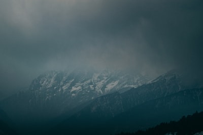 雪覆盖的山脉在灰色的天空下
